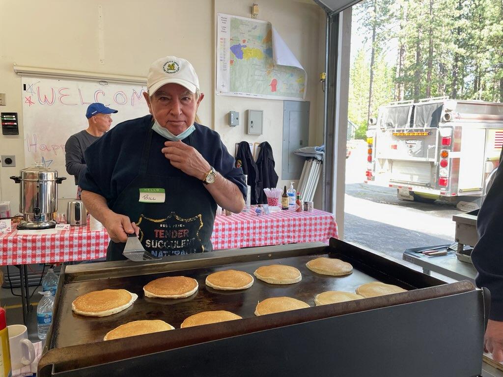 Firefighter flipping pancakes for a breakfast fundraiser.